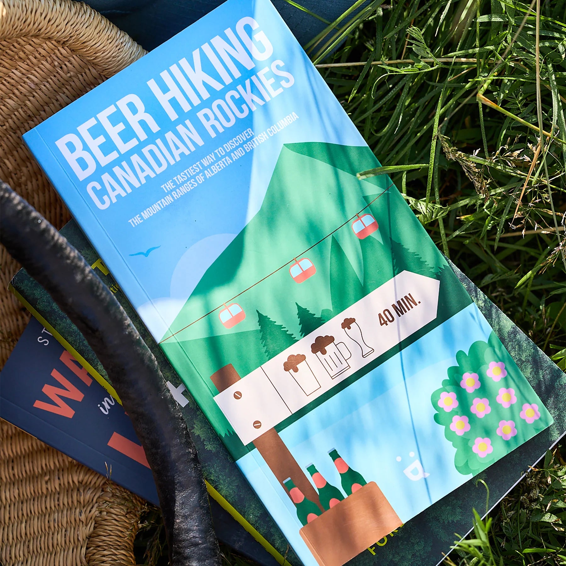 Book titled 'Beer Hiking Canadian Rockies' on a grassy background