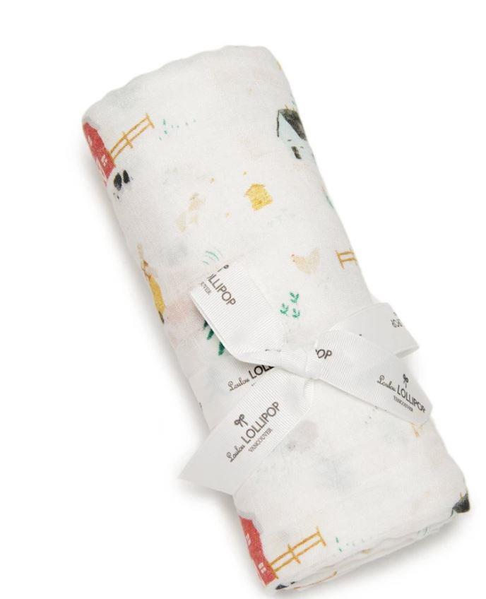farm animals swaddling baby blanket features red barns, chicken and cows grazing
