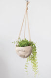 cream colored holding hands cement hanging planter
