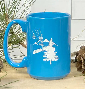 The Ski Lift Mug is a great addition to your ski cabin or chalet. When you come home after a great day of skiiing there is nothing better than a hot cup of cocoa or a hot toddy. The mug is teal with a ski life and trees in the background